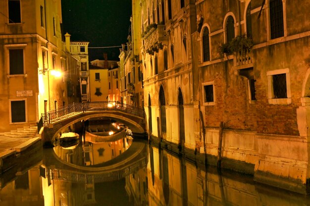 Canales de Venecia iluminados por la noche en Italia.