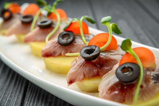 Canapé de arenque con papa y cebolla.