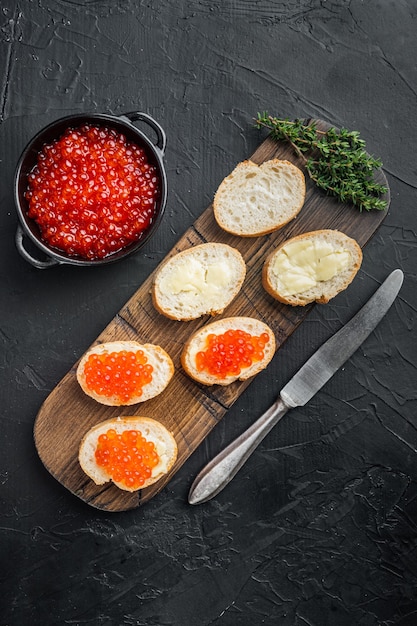 Canapé com caviar de salmão vermelho, para o ano novo, na mesa preta, vista de cima plana lay