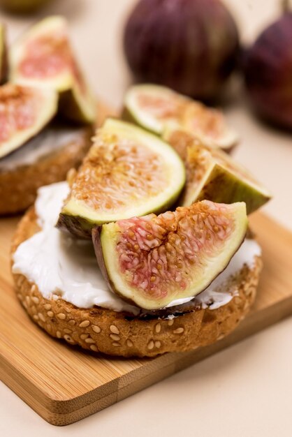 Canapé o crostini con queso crema baguette tostado e higos sobre tablero de madera Delicioso aperitivo