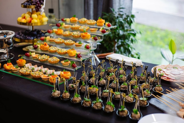 Canape-Vorspeisen auf dem Tisch, Buffet-Menü, europäische Küche, Garnelen-Mini-Burger auf einem hölzernen Hintergrund