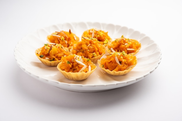 Canapé de zanahoria o Gajar Halwa o canapé o Tarta de fusión, aderezado con frutos secos. Postre indio