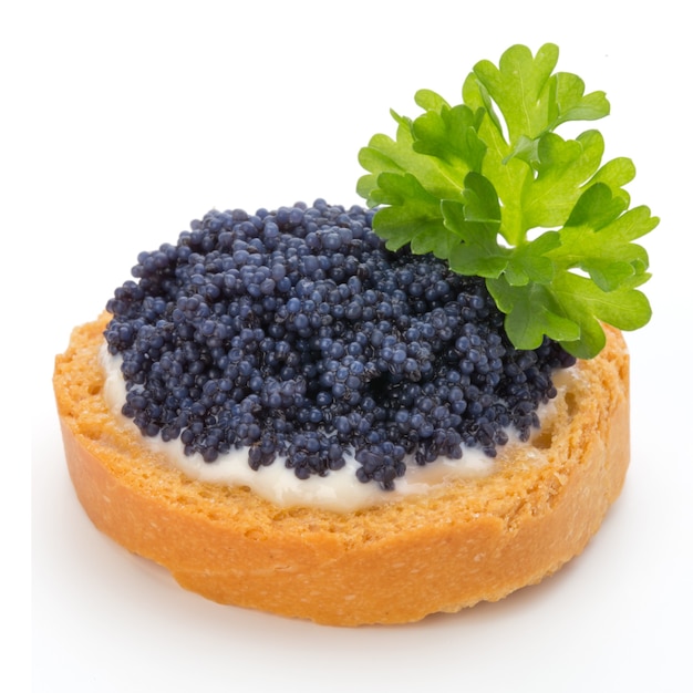 Canapés con caviar de esturión negro y perejil. Aislado en la superficie blanca.