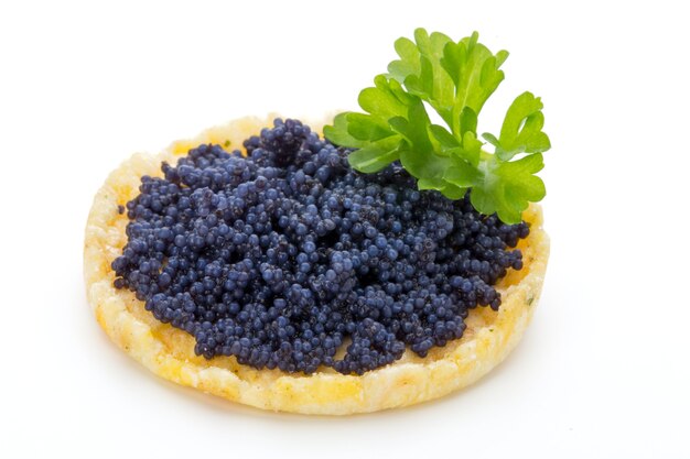 Canapés con caviar de esturión negro y perejil. Aislado