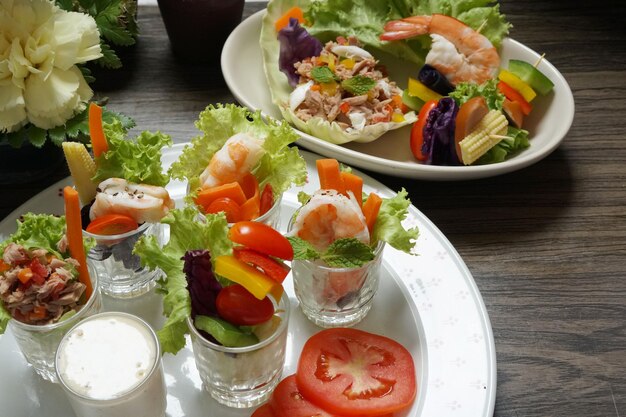 Canapés de salada mista com molho em um prato no fundo de madeira