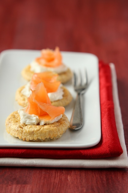 Foto canapés con galletas de salvado de avena, salmón ahumado y queso crema