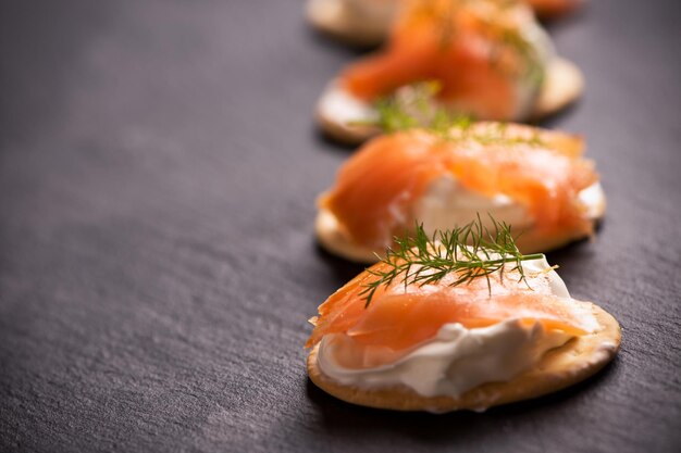 Canapes mit Lachs auf schwarzem Hintergrund Nahaufnahme isoliert