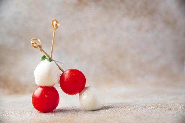 Canapés, mozzarella y tomate, ensalada caprese en una brocheta.