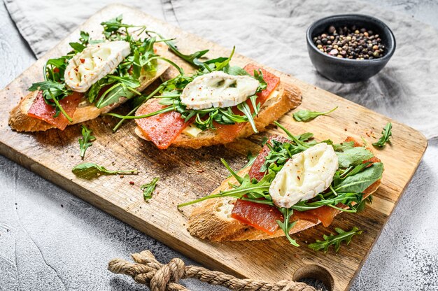 Canapés na baguete com queijo de cabra, rúcula e geleia de pêra