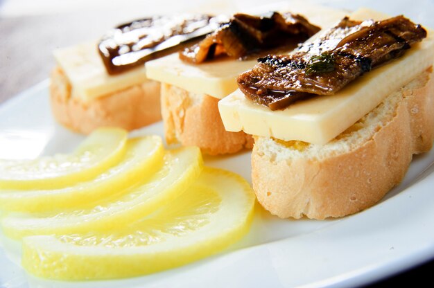 Canapés o crostini en pizarra. Ideal como aperitivo. Ingredientes: baguette tostado con semillas de girasol y lino, mermelada de cebolla, queso crema y tomillo fresco.