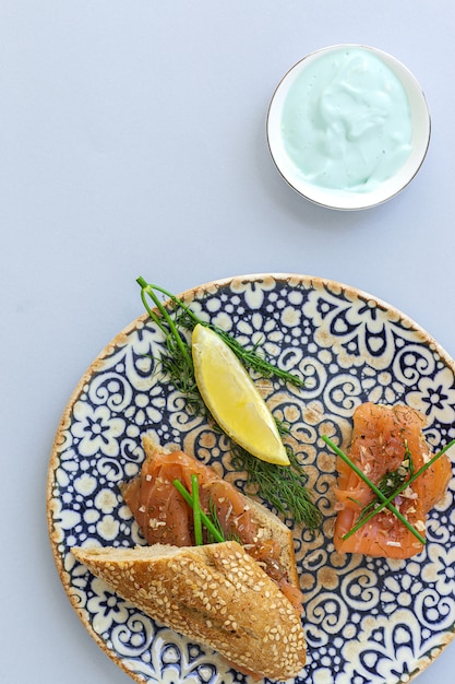 Canapés de salmón ahumado noruego con limón, salsa de queso azul, pimienta y sal