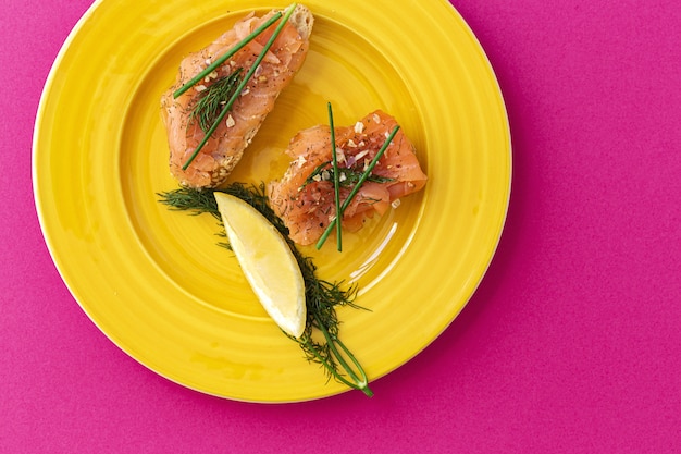 Canapés de salmón ahumado noruego con limón, salsa de queso azul, pimienta y sal