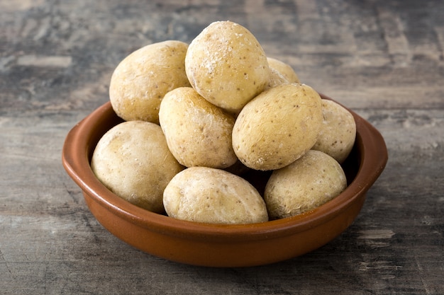 Canárias batatas na mesa de madeira.