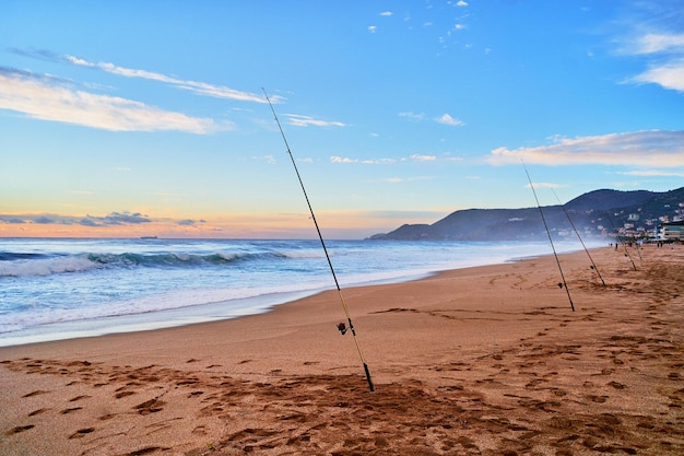 Cañas giratorias para pescar en la costa arenosa del mar