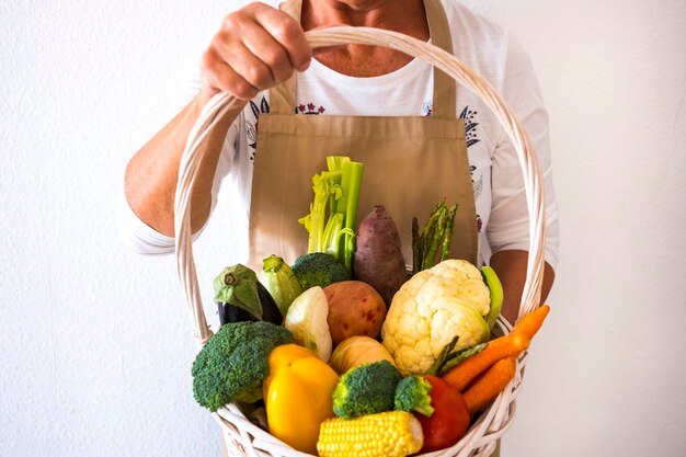 canasta blanca en manos femeninas humanas llenas de vegetales frescos y saludables