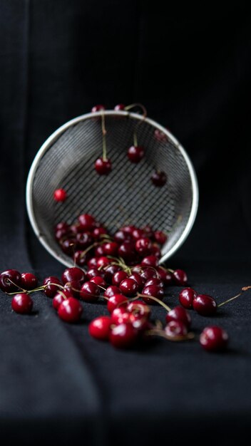 Foto una canasta con cerezas en ella y un fondo negro