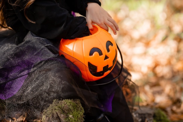 canasta de dulces de calabaza jack lantern en manos de una niña halloween