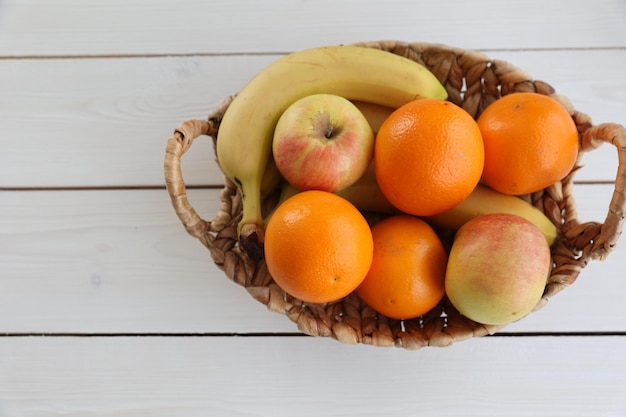 Una canasta de frutas sobre un fondo blanco.