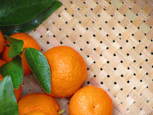 Una canasta con naranjas y hojas