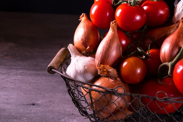 canasta vieja con tomates cebolla ajo.