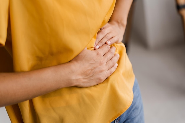 Câncer de estômago e esôfago de menina africana A mulher doente está segurando seu estômago porque dói Pancreatite A doença do pâncreas fica inflamada