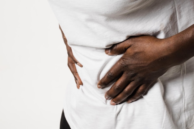 Cáncer de estómago y esófago de un hombre africano Un hombre afroamericano enfermo sostiene su estómago porque le duele Pancreatitis La enfermedad del páncreas se inflama
