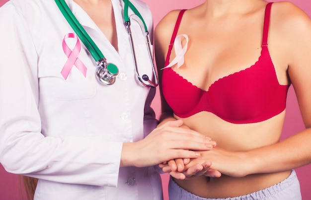 Foto cáncer de mama el médico sostiene la mano del paciente como un signo de apoyo lucha contra el cáncer cinta rosa