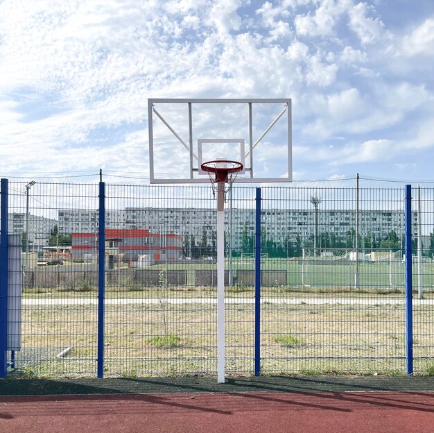 Una cancha de baloncesto, un aro de canasta contra el cielo