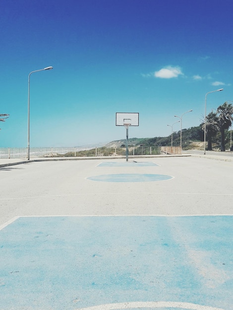 Foto una cancha de baloncesto vacía contra el cielo azul.