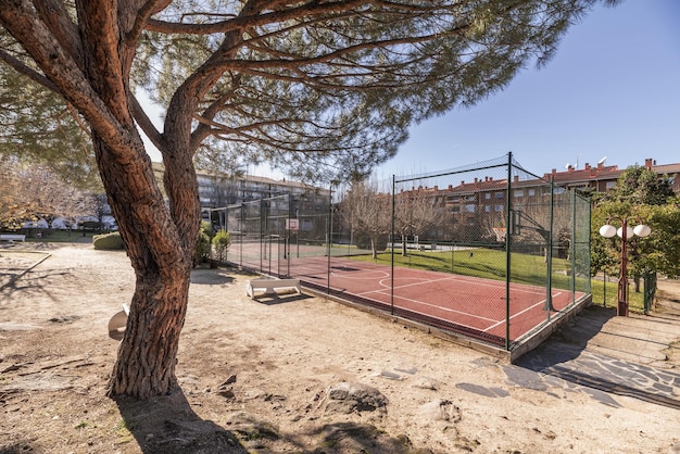 Una cancha de baloncesto con una valla metálica perimetral