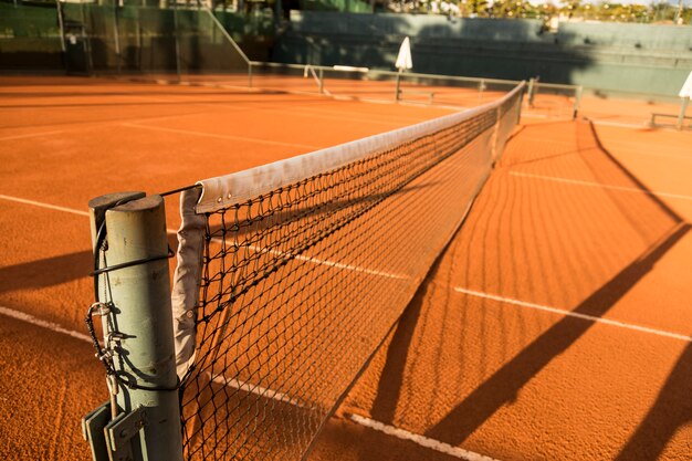 Cancha de tenis de arcilla (tierra), bajo la puesta de sol.