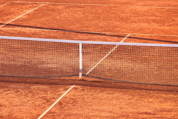 Cancha de tenis de arcilla vacía y Net. Tiro horizontal