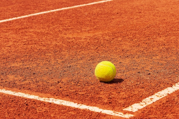 Cancha de tenis Pelota de tenis en una cancha de tierra batida cerca de la línea