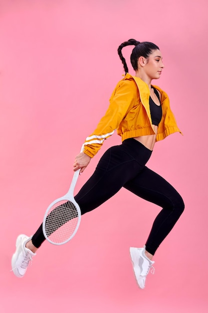 Las canchas de tenis están llamando y debo ir Foto de estudio de una joven deportista saltando con una raqueta de tenis sobre un fondo rosa