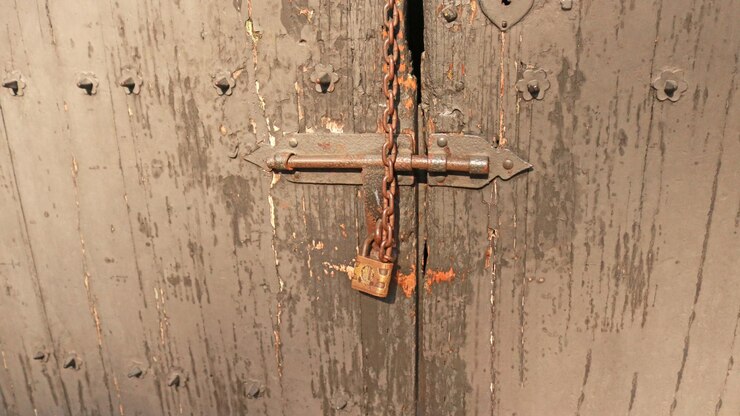 Candado en puerta de madera. Antiguo. Cerradura con llave. Puerta de madera cerrada. Sin pasar.