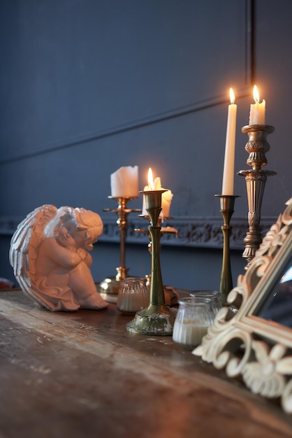 Candelabro antiguo con vela encendida en la mesa de madera antigua