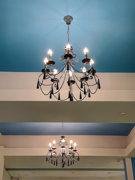 Candelabro com lâmpadas em forma de velas em um teto azul