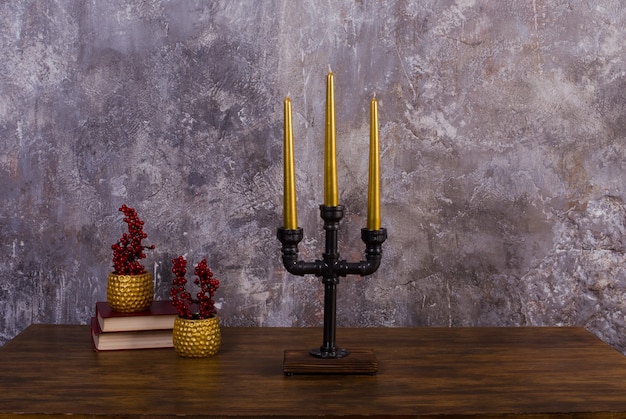 Candelabro para tres velas de metal estilo loft y velas doradas diseño interior