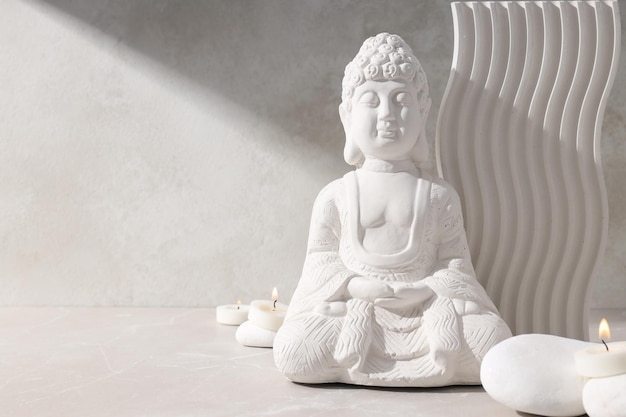 Candelas y piedras de la estatua de Buda en el fondo beige espacio para el texto
