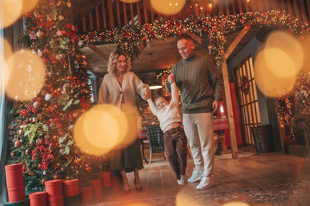 Foto candid autêntica família feliz durante o inverno juntos desfrutando de férias em cabana de madeira no xmas