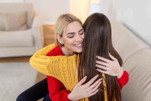 Foto candid diversas chicas mejores amigas abrazando de pie en el interior de cerca satisfecho mujeres cara disfrutar de momento tierno perdido contento de verse unos a otros después de larga separación amistad concepto de relaciones cálidas