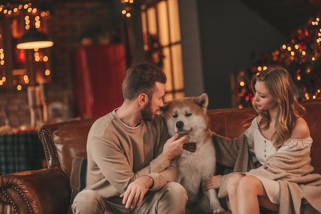 Cândido casal feliz e autêntico passa tempo junto com cachorro japonês no Xmas lodge