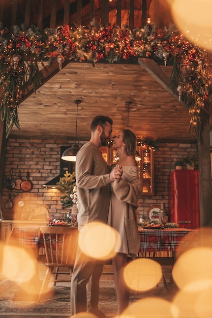 Cândido casal feliz e autêntico passando tempo juntos no alojamento de madeira Xmas decorado