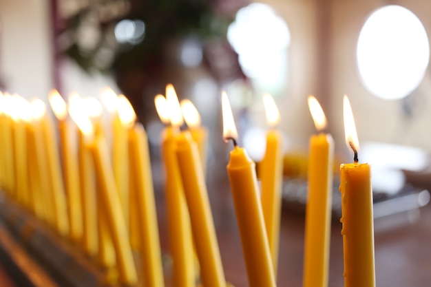 Candles a luz de queimar-se no templo no fundo abstrato das velas.