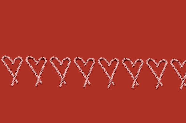 Candy Cane Sticks in Form eines Herzens auf rotem Grund. Nahtloses Muster des Weihnachtsfeiertags. Neujahr Tapete.
