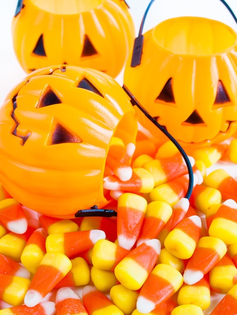 Foto candy corn bonbons, die aus der halloween-leckerei-tasche fallen.