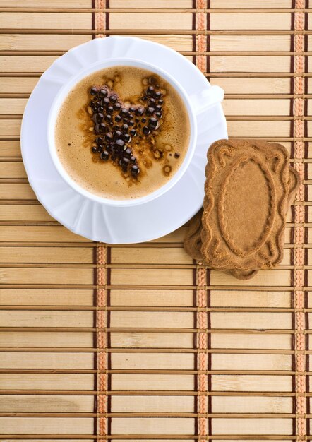 Caneca azul com café expresso com biscoitos em um tapete wum