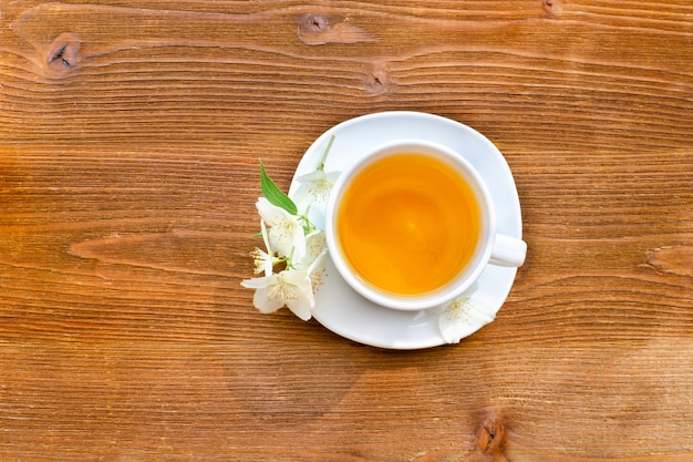 Caneca branca de chá em uma mesa de madeira marrom.
