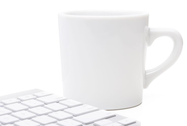 Foto caneca branca e teclado de computador
