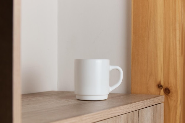 Caneca branca para chá e café em uma mesa de madeira fechada
